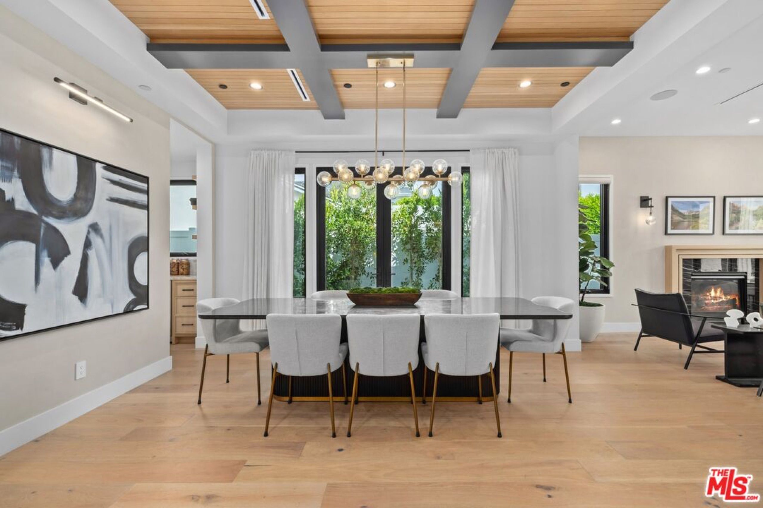 Dining room under a beamed ceiling with chandelier