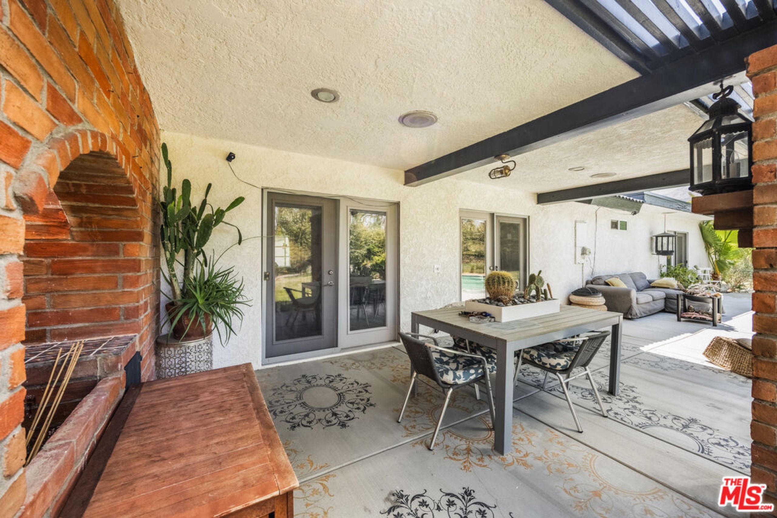 Covered patio with brick fireplace and outdoor dining