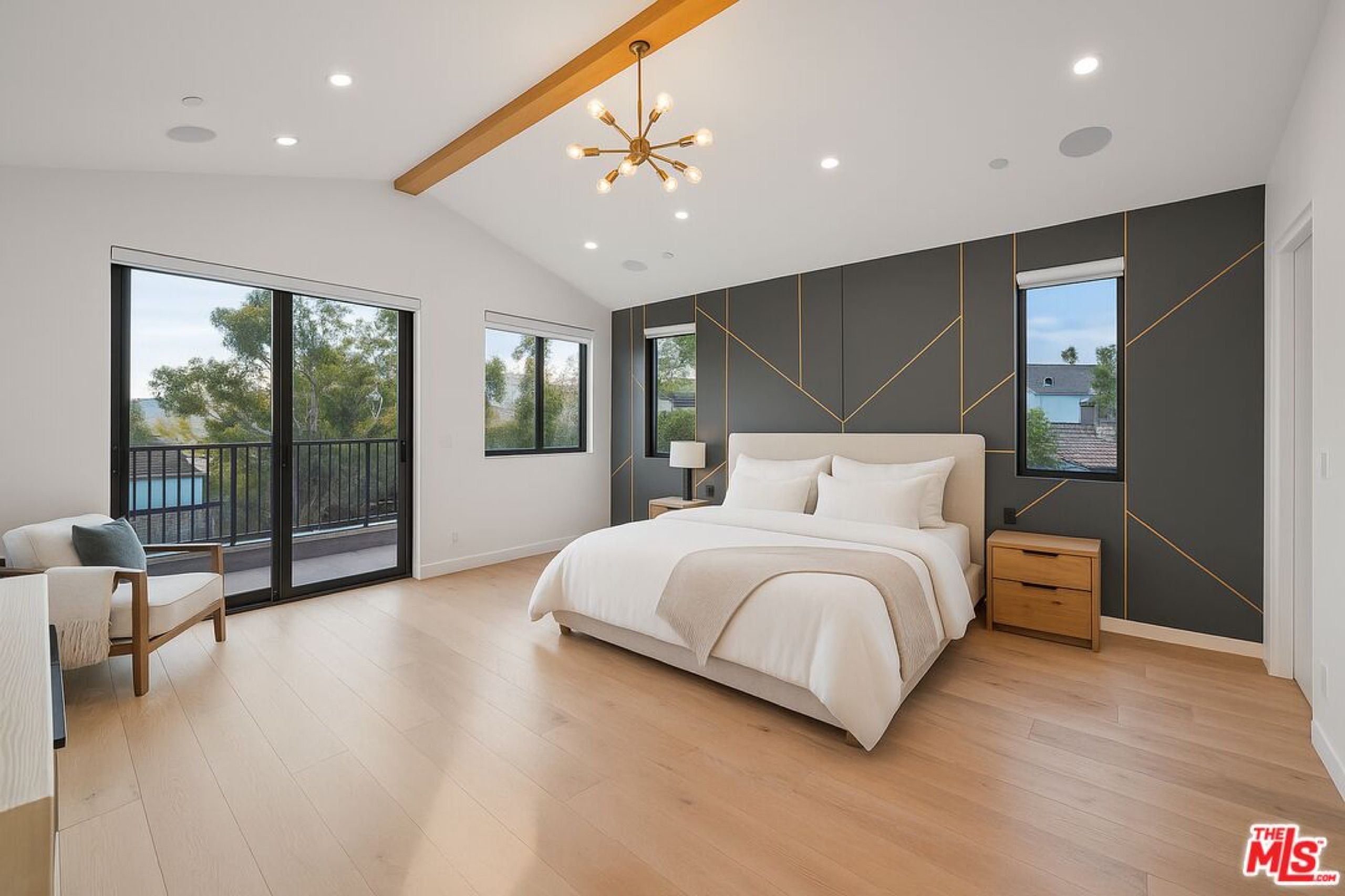 Primary bedroom with vaulted ceiling and balcony doors