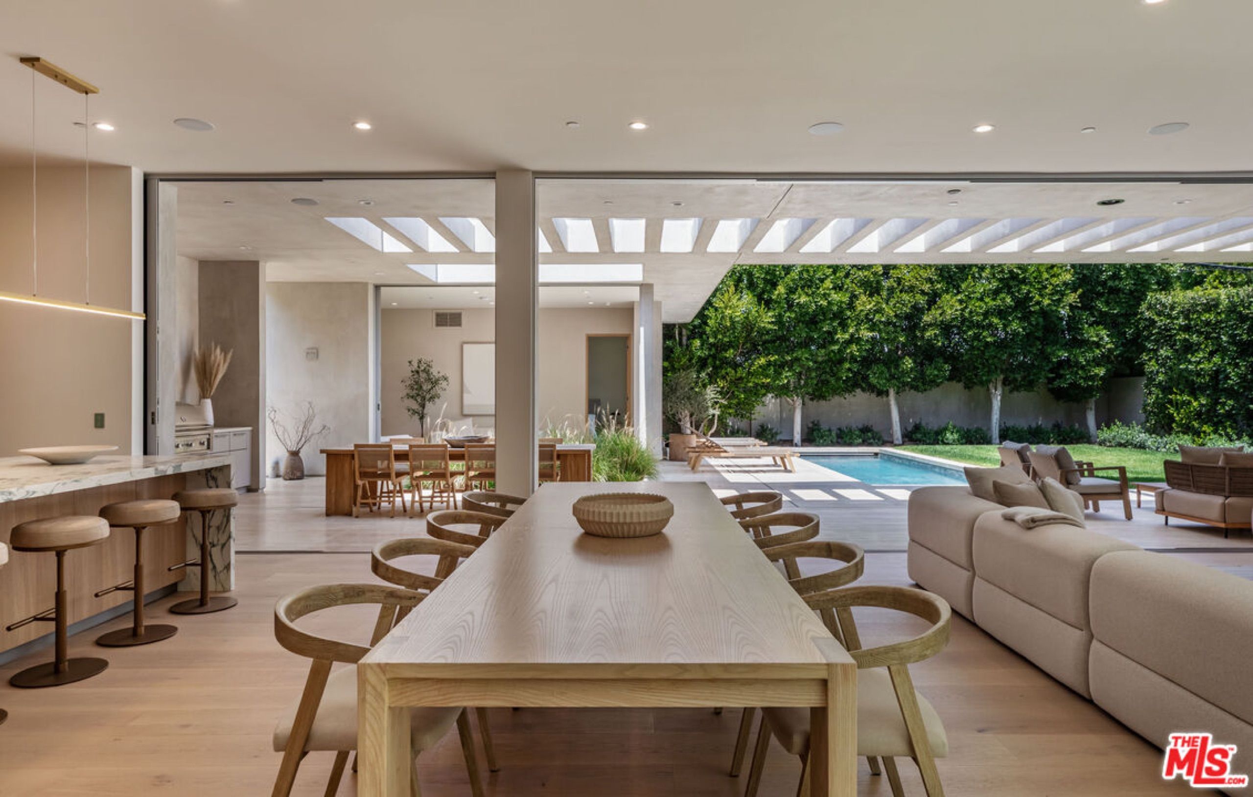 Dining table and kitchen island looking out to the pool
