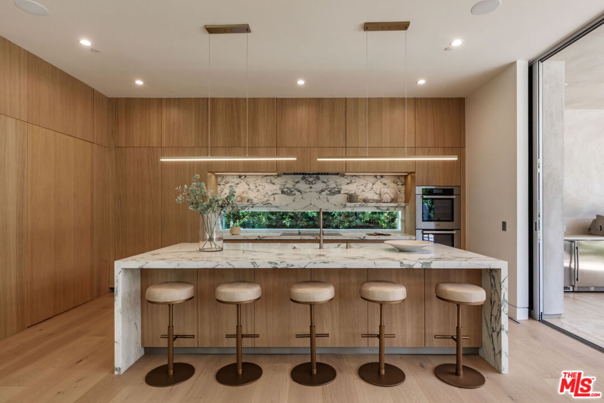 Kitchen with marble waterfall island and oak cabinetry