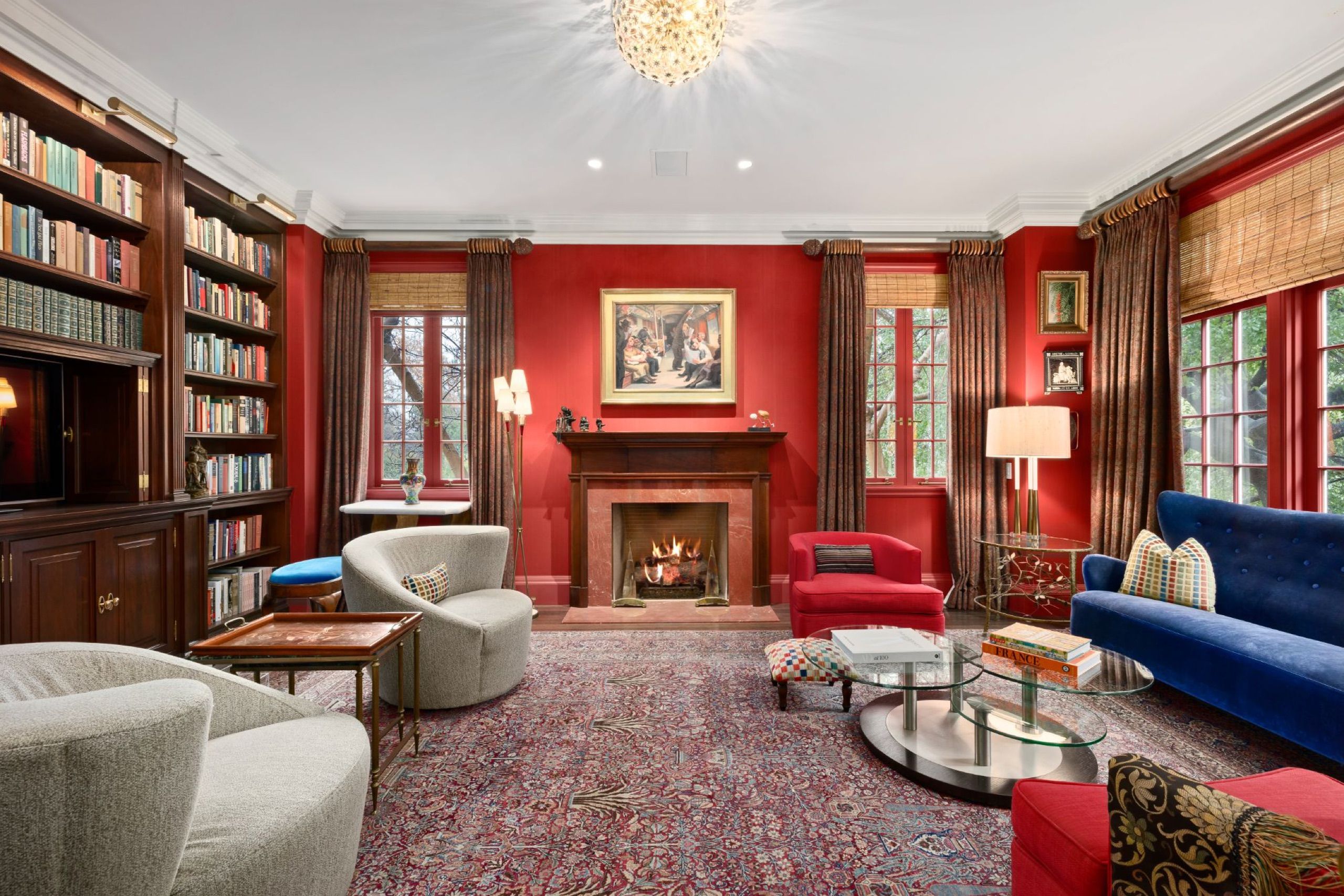 Mahogany paneled library with marble fireplace and red walls