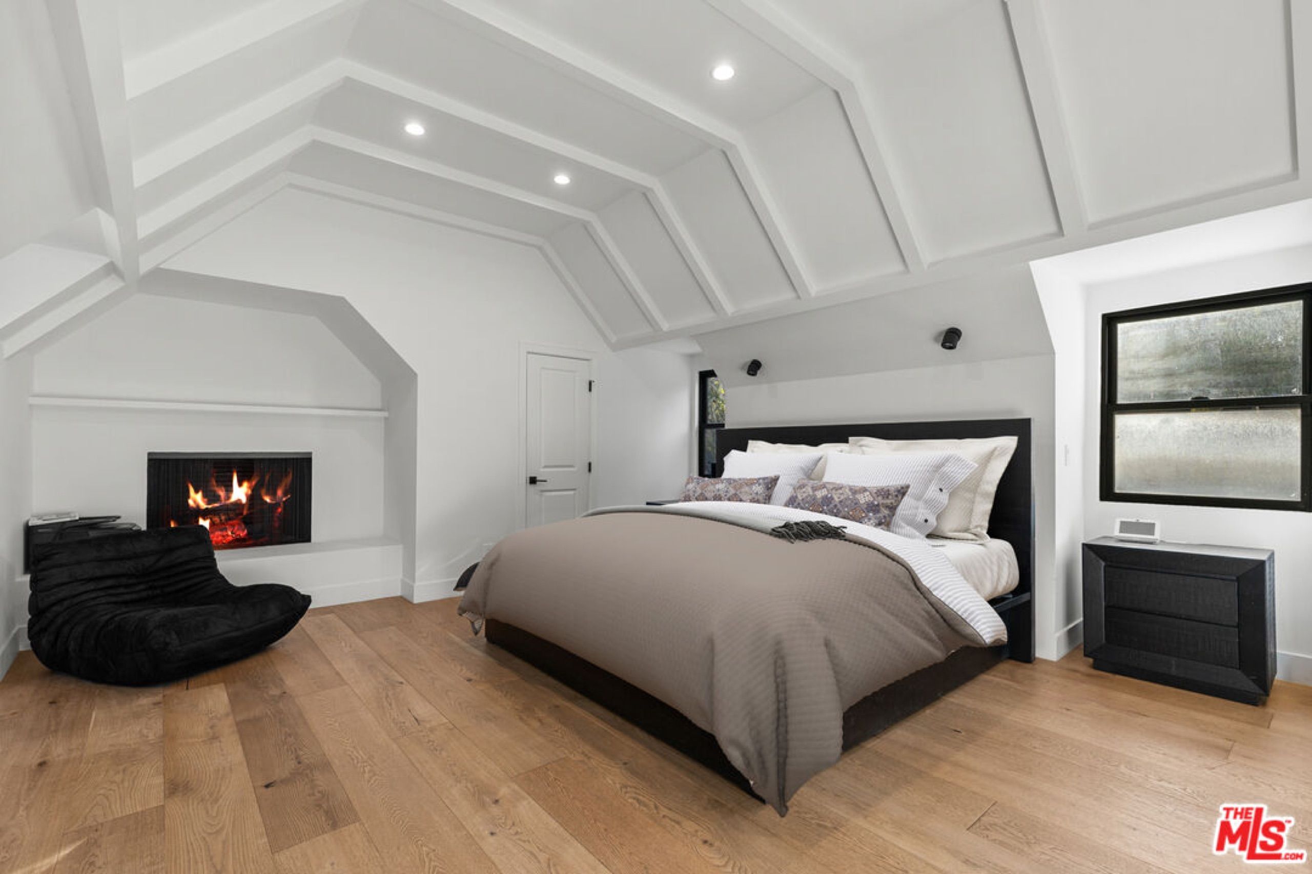 Primary bedroom with vaulted ceiling and fireplace
