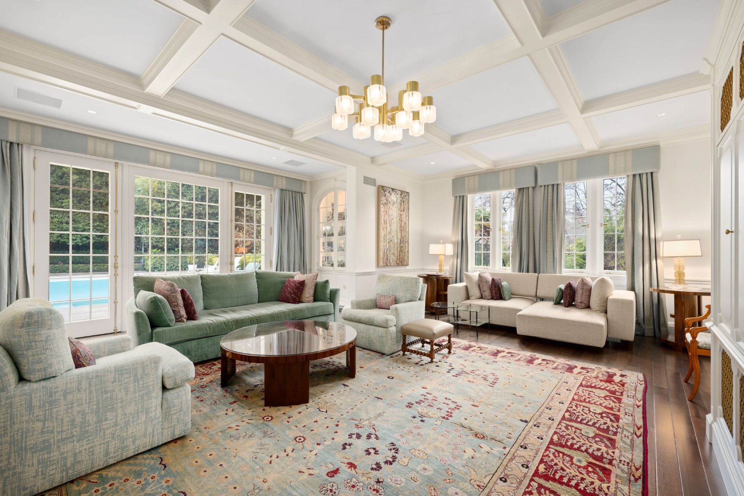 Family room with coffered ceiling overlooking the pool