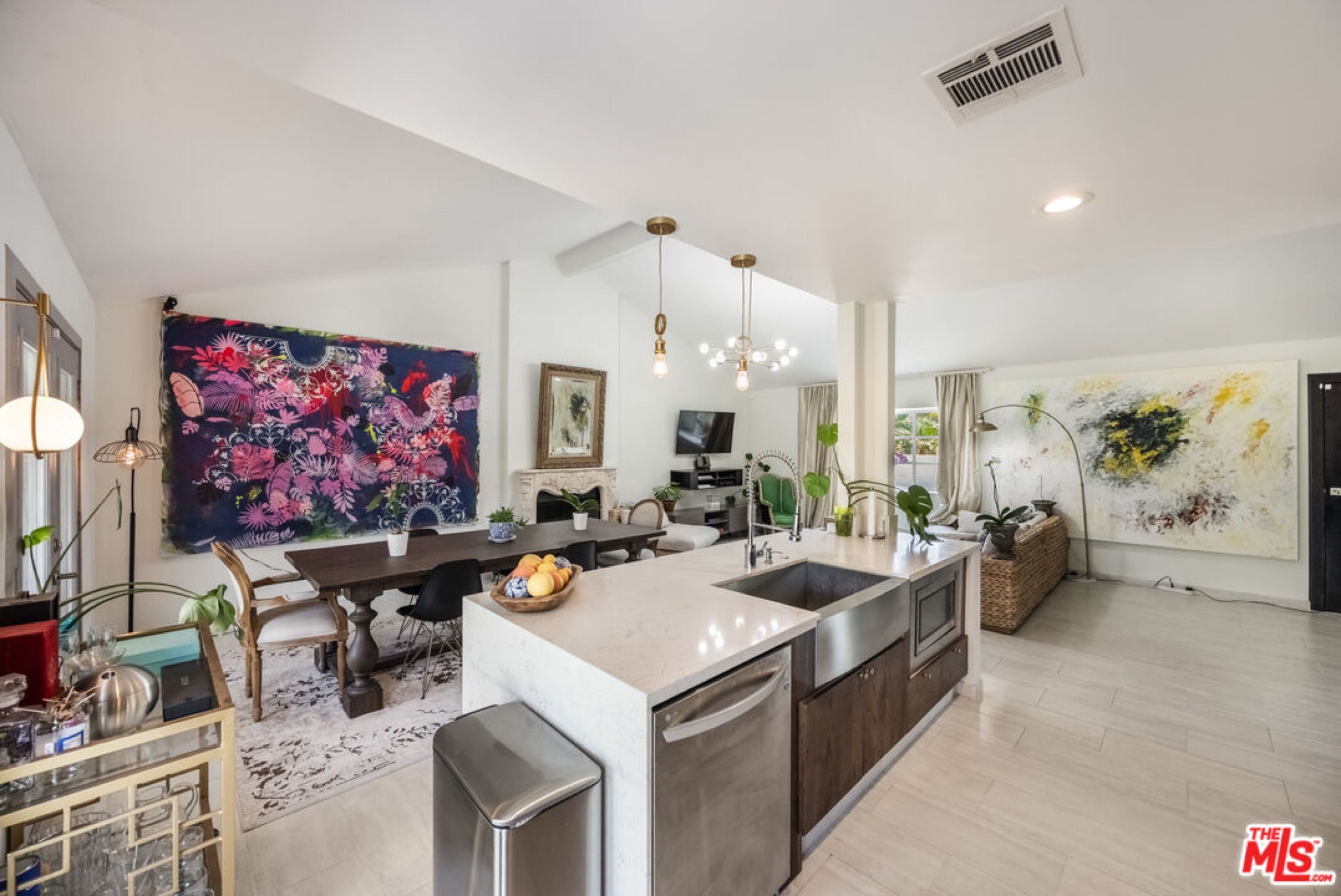 Open kitchen with white island and living room beyond
