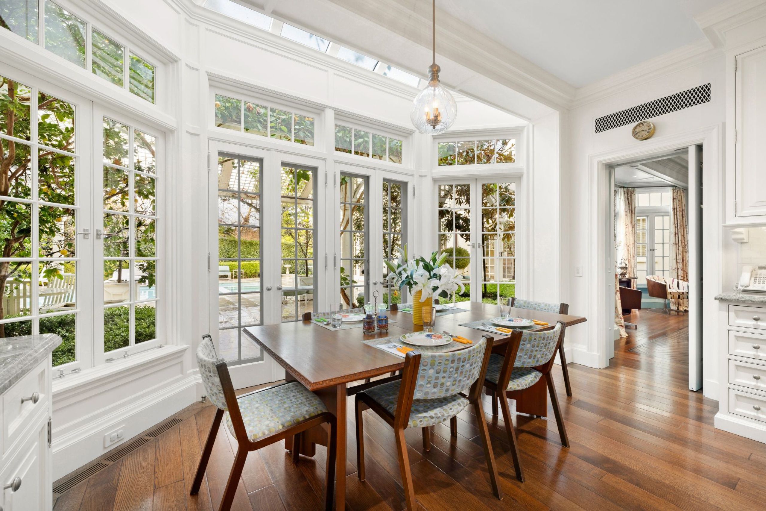 Sunlit breakfast room surrounded by French windows
