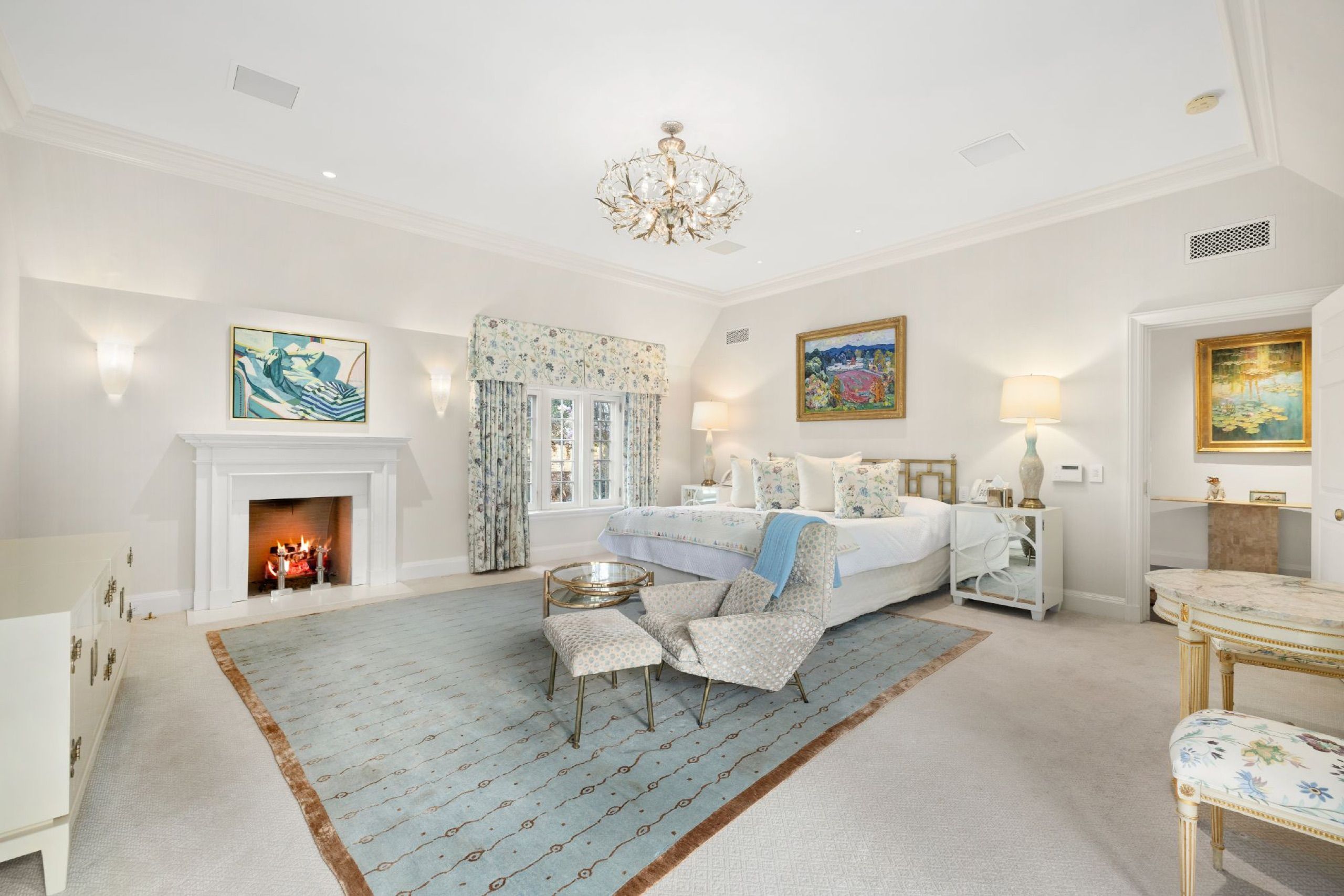 Primary bedroom with fireplace and soft blue rug