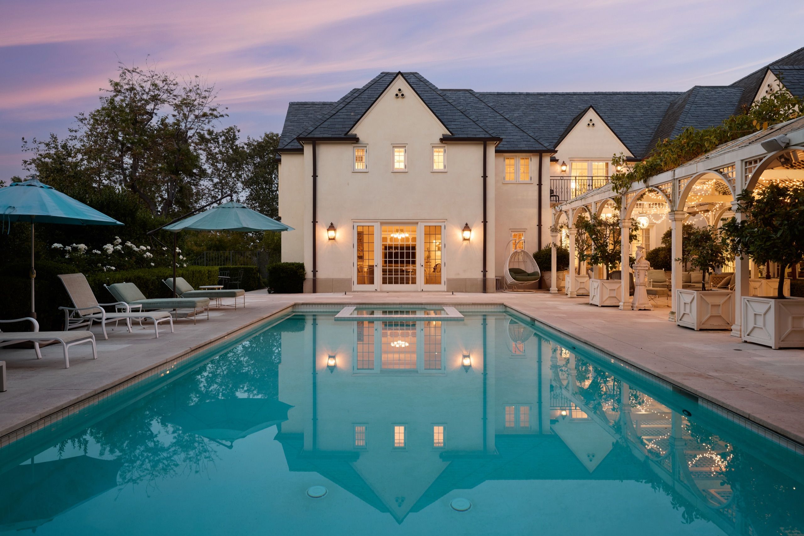 Saltwater pool and illuminated pergola at dusk, 10301 Strathmore Drive